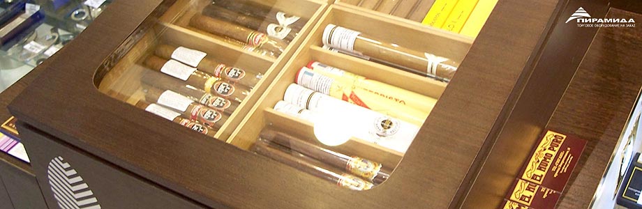 Торговое оборудование для сигарет, сигар и табака. На переднем плане хьюмидор, облицованный шпоном венге